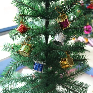 Close-up of colorful miniature drum ornaments hanging on green Christmas tree branches