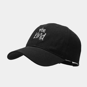 Detail of embroidered 'be kind' text and heart on black cotton baseball cap