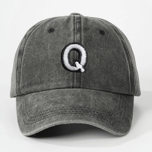 Close-up of embroidered letter Q on washed charcoal grey cotton baseball cap detail