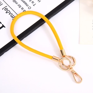 Close-up of yellow PU leather wrist strap keychain with golden metal spring ring clasp