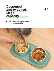 Close-up of double pet feeding bowls with stainless steel inserts and a green base