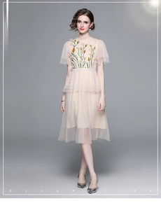 Close-up of elegant mesh dress featuring detailed floral embroidery and sequin embellishments
