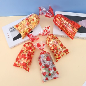Clear cellophane candy bags with red heart patterns and gold twist ties for treats