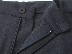 Gros plan détaillé du short gris foncé montrant le bouton de taille et le zip métallique