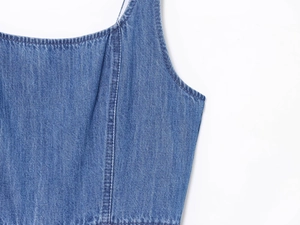 Dettaglio della trama del tessuto denim blu e cuciture di un abito con fondo svasato