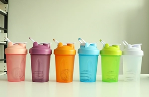 Six colorful sports protein shakers with mixing balls shown in pink, blue and more