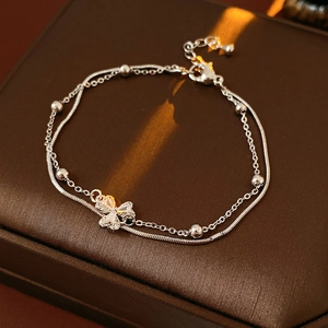 Makroaufnahme von versilbertem Kleeblatt-Armband mit Zirkon-Steinen auf Ledergrund
