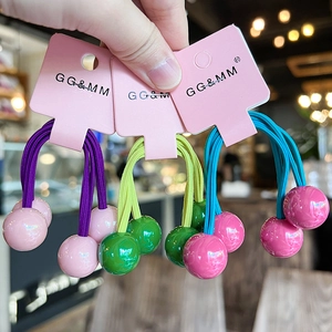 Close-up of colorful double ball hair ties in purple, yellow, and blue pastel combinations