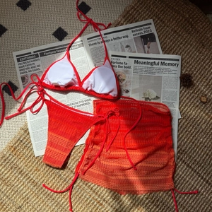 Detail of red ombre textured bikini set with adjustable ties and mesh cover-up skirt
