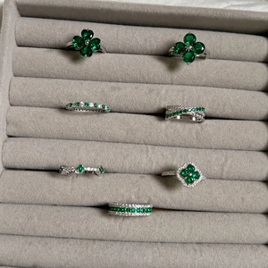 Set of vintage S925 sterling silver rings with green zircon clover design on grey display