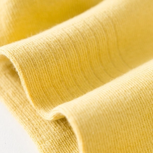 Detailed texture of bright yellow low cut cotton socks with high-density ribbed knit design