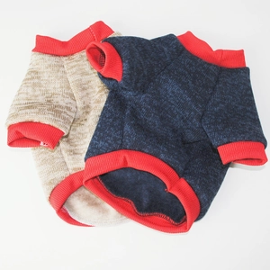 Detailed close-up of dark blue and beige dog sweaters with red ribbed trim and warm knit texture