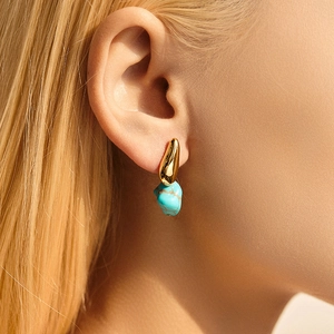 Elegant 18K gold-plated earrings with irregular turquoise stone shown on model
