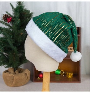 Détail du bonnet de Noël en velours vert avec rayures dorées et bordure en peluche blanche