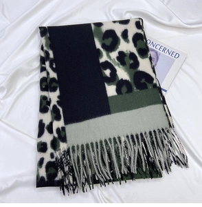 Detailed view of leopard print scarf featuring tassel edges and color-block knit texture
