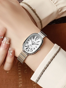 Close-up of a silver oval quartz watch with steel band on woman's wrist
