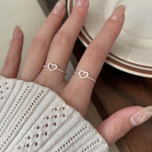 Close-up of a 925 sterling silver heart ring with twisted band on a model's hand