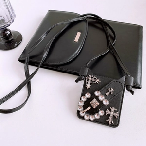 Detailed view of black gothic phone bag featuring silver rhinestone cross and punk buckles