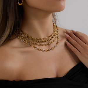 Gros plan d'un collier à maillons superposés bicolores en métal poli or et argent de luxe