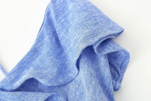Close-up of ruffles on light blue linen blend dress showing detailed fabric texture
