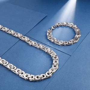 Punk silver stainless steel Byzantine chain necklace and bracelet set on blue background