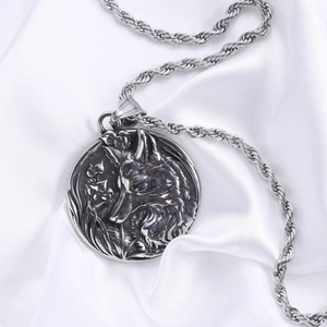 Detail of vintage wolf head pendant on silver twisted rope chain over white silk fabric