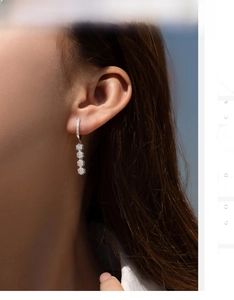 Detail of S925 sterling silver dangling flower earrings with shimmering cubic zirconia