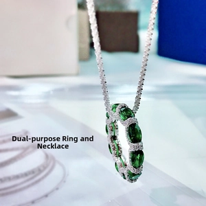 Detailed macro view of the dual-use ring and necklace with green oval gemstones and zircons
