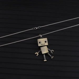 Close-up of vintage silver robot pendant necklace with movable limbs and lobster clasp