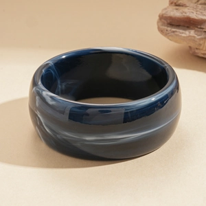 Detail of dark blue marble pattern acrylic bangle with white smoky texture