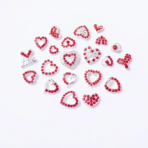 Mix of heart-shaped nail charms with red rhinestones and silver metal settings