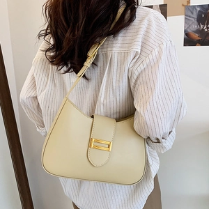 Minimalist beige leather baguette shoulder bag with gold buckle and adjustable strap