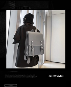Grey vintage faux leather backpack shown on a model in a modern bright setting