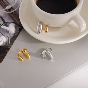 Detailaufnahme der organisch geformten Gold- und Silberringe auf einem Schreibtisch