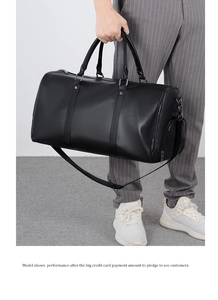 Detail of black lychee leather travel bag with shoe compartment and silver hardware