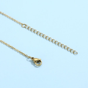Detailed macro view of the gold necklace lobster clasp and adjustable extender chain link