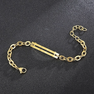 Détail d'un bracelet en acier doré avec barre rectangulaire polie et fermoir mousqueton robuste