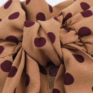 Detail of a brown and burgundy polka dot bow tie with high-quality twill fabric texture
