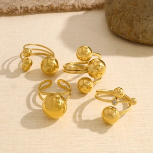 Macro shot of gold-plated ball rings featuring polished spheres and sparkling zircons