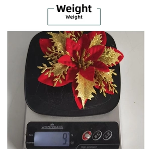 Detailed view of lightweight 9g red glitter Christmas flower on a digital scale