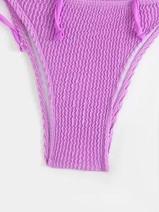 Detailed close-up of smocked lilac bikini bottom with ribbed texture and side ties