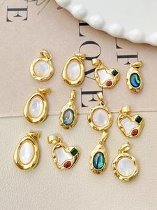 Detail of 18k gold-plated heart and shell pendants for DIY jewelry making and crafts