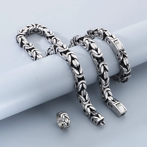 Set collana a catena bizantina e anello argento esposti su piedistalli bianchi