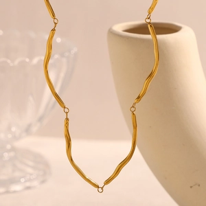 Macro detail of 18K gold-plated wavy joint link necklace with high-shine metallic finish