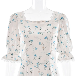 Detail of square neckline and puff sleeves with delicate lace trim on floral satin dress