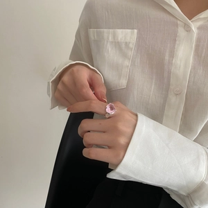Detailed view of pink heart-shaped gemstone ring with a polished silver band on a model