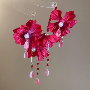 Detail of red fabric flower earrings with white pearls and long pink crystal tassels