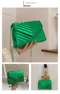 Detail of green patent leather crossbody bag with V-quilted texture and gold chain strap