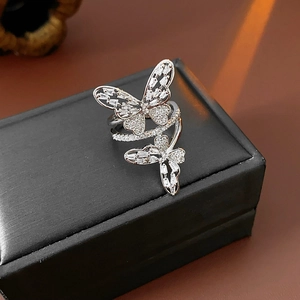 Detailed view of silver butterfly ring with cubic zirconia stones on black box