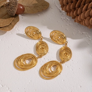 Vintage 18K gold plated stainless steel spiral tassel earrings on artistic background